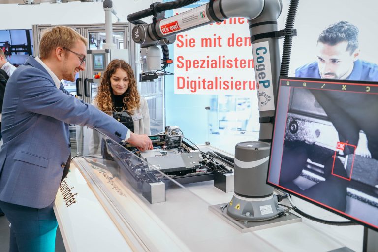 Ein Roboter für die Echtgeldprüfung: Henning Peters, wissenschaftlicher Mitarbeiter vom Fraunhofer IEM, präsentiert den in einem it’s OWL Projekt entstandenen kollaborativen Roboter (Cobot) auf der FMB – Fachmesse für Maschinenbau. Der Cobot soll Diebold Nixdorf beim Echtgeldtest von Geldautomaten und der Montageprüfung von Bedienfeldern an Geldautomaten unterstützen. (Foto: it's OWL)