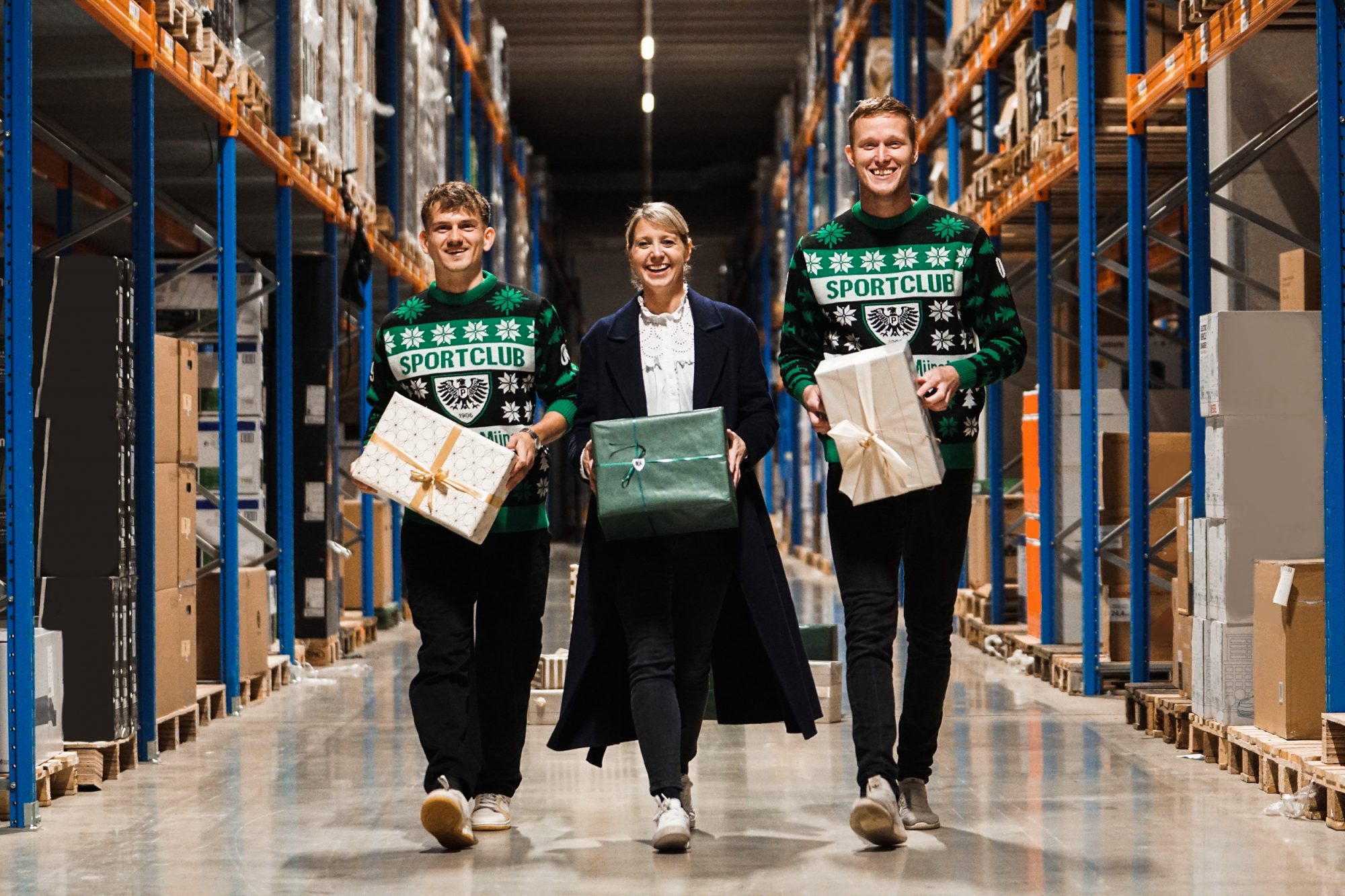 Verschenken Überraschungsmomente in der Vorweihnachtszeit: Die Preußen-Kicker Thorben Deters (l.) und Gerrit Wegkamp (r.) sowie Sarah Schimmelpfennig, Executive Director Marketing & Communications bei Preußen-Hauptsponsor Fiege. (Foto: SC Preußen Münster/Fiege)