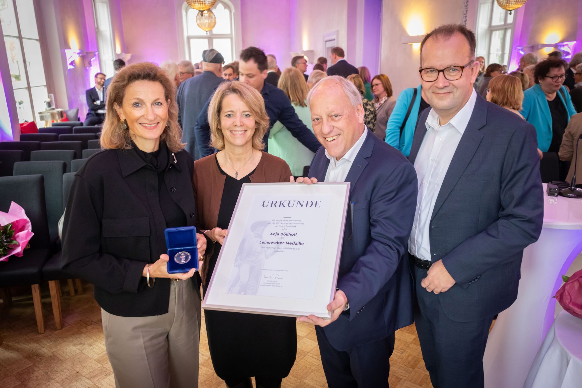 Während der feierlichen Verleihung in der Villa Bozi übergeben Ursula Pasch (2. v. l., Vorsitzende des Verkehrsvereins), Oberbürgermeister Pit Clausen (2. v. r.) und Martin Knabenreich (Geschäftsführer Verkehrsverein) die Leineweber-Medaille und die Urkunde des Verkehrsvereins an die Preisträgerin Anja Böllhoff (l.). (Foto: Bielefeld Marketing/ Sarah Jonek)