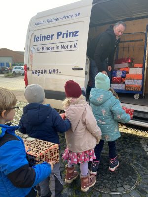 Päckchen packen für den guten Zweck: Die Kinder der KiTa Zappelkiste füllen in inzwischen alter Tradition zusammen mit dem Unternehmen WESSLING den Transporter der Aktion Kleiner Prinz, der sich jetzt mit den Geschenken auf den Weg nach Media und Satu Mare in Rumänien gemacht hat. (Foto: KiTa Zappelkiste)