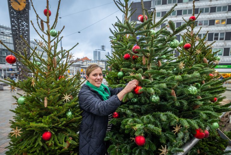 Julia Lehmann, City-Managerin bei Bielefeld Marketing, verteilt 40 geschmückte Tannen in der Bielefelder Innenstadt. (Foto: Bielefeld Marketing/ Sarah Jonek)