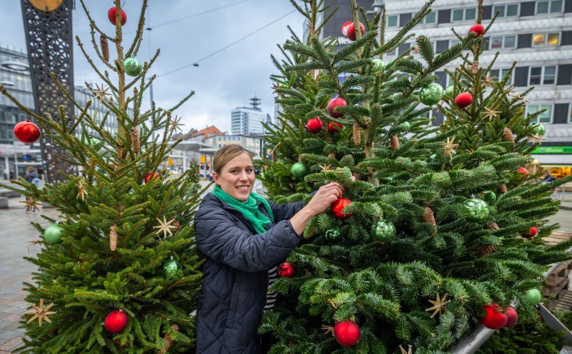 Julia Lehmann, City-Managerin bei Bielefeld Marketing, verteilt 40 geschmückte Tannen in der Bielefelder Innenstadt. (Foto: Bielefeld Marketing/ Sarah Jonek)