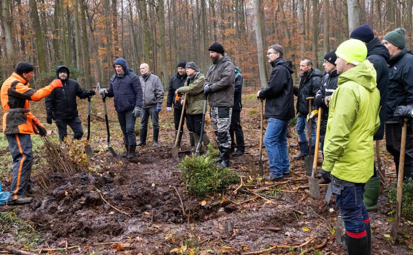 Förster Peter Heidmeier (links) erklärt den fleißigen Helfern, worauf sie beim Einpflanzen zu achten haben. (Foto: Gauselmann)