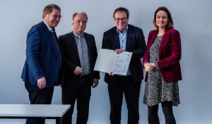 Von links: Professor Dr. Stefan Witte, Vizepräsident für Forschung und Transfer, sowie Professor Dr. Thomas Schulte, Dekan des Fachbereichs Elektrotechnik und Technische Informatik, nahmen die Förderzusage für die Campusbahn von NRW-Verkehrsminister Oliver Krischer dankend entgegen. Anna Katharina Bölling, Regierungspräsidentin im Regierungsbezirk Detmold, hatte die Papiere mitgebracht. (Foto: TH OWL)