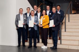 Die Regierungspräsidentin überreichte die Förderbescheide (v.l.n.r.): Prof. Dr. Rainer Rasche, TH OWL (Teilprojektleitung), Sebastian Brauner, Geschäftsführer der Verler Immobilien- und Wirtschaftsförderungsgesellschaft (Geschäftsführer; Teilprojektleitung), Robin Rieksneuwöhner, Bürgermeister der Stadt Verl, Prof. Dr. Franz Kummert, Universität Bielefeld (Teilprojektleitung), Prof. Dr. Rolf Naumann, HSBI, Dekan Fachbereich Ingenieurwissenschaften und Mathematik (Projektleitung), Anna Katharina Bölling, Regierungspräsidentin, Prof Dr. Peter Reinold, HSBI (Teilprojektleitung), Prof. Dr. Ulrich Rückert, Universität Bielefeld, Prorektor für Digitalisierung und Dateninfrastruktur, Prof. Dr. Anant Patel, Vizepräsident für Forschung und Entwicklung an der HSBI (Foto: P. Pollmeier / HSBI)
