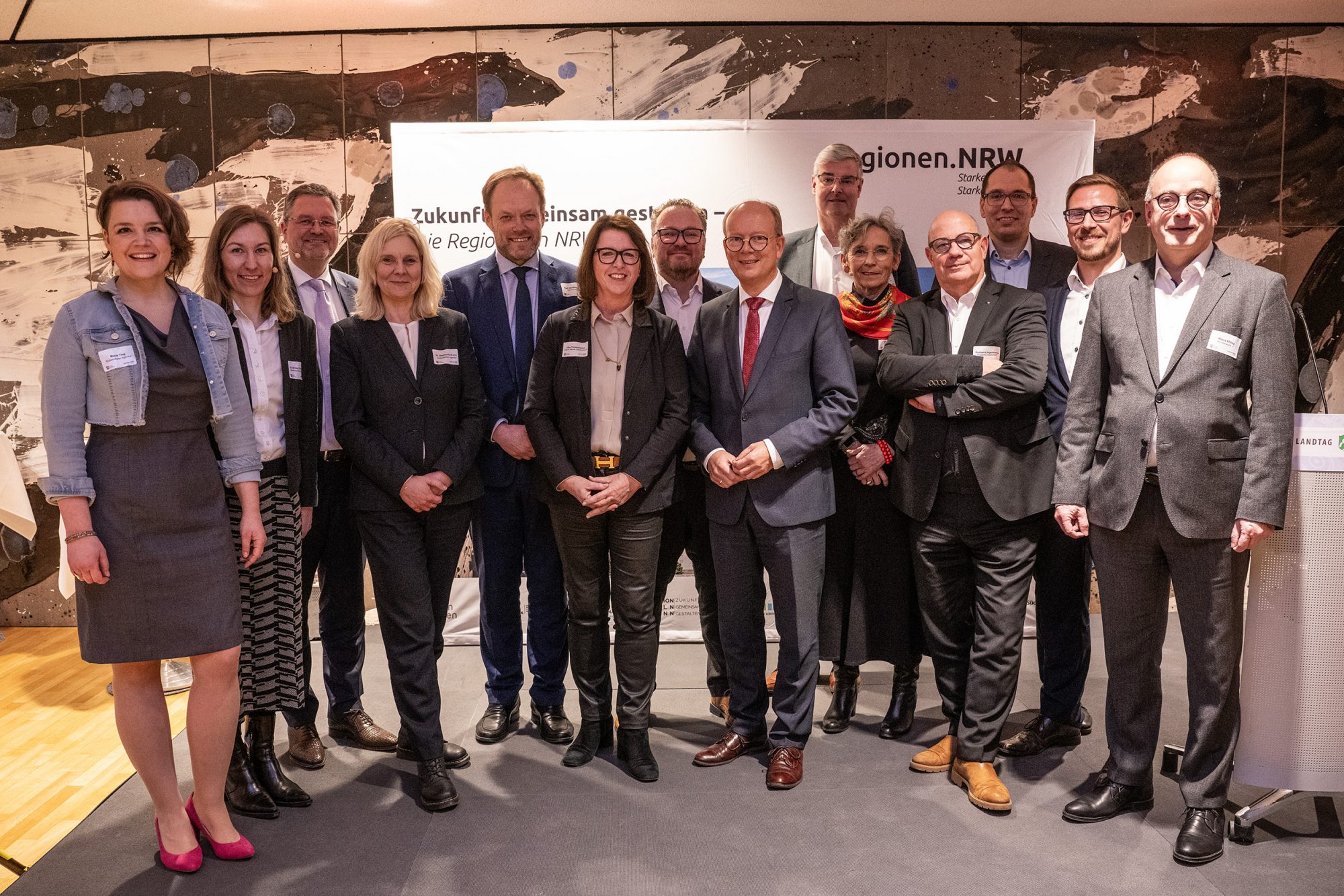 (v. l.) Marie Ting (Südwestfalen Agentur), Dr. Verena Svensson (Stadtwerke Düsseldorf AG), Bodo Middeldorf (Zukunftsagentur Rheinisches Revier), Dr. Stephanie Arens (Südwestfalen Agentur), Kurt Vandenberghe (EU-Kommission), Ulla Thönnissen (Region Aachen Zweckverband), Björn Böker (Ostwestfalen-Lippe GmbH), André Kuper (Landtag NRW), Markus Schlüter (Regionalverband Ruhr), Monika Kocks (automotiveland.nrw), Stephan A. Vogelskamp (Bergische Struktur- und Wirtschaftsförderungsgesellschaft mbH), Bertram Gaiser (Standort Niederrhein GmbH), Paul Stertz (Regionalmanagement Düsseldorf – Kreis Mettmann) und Klaus Ehling (Münsterland e.V.). (Foto: Münsterland e.V.)