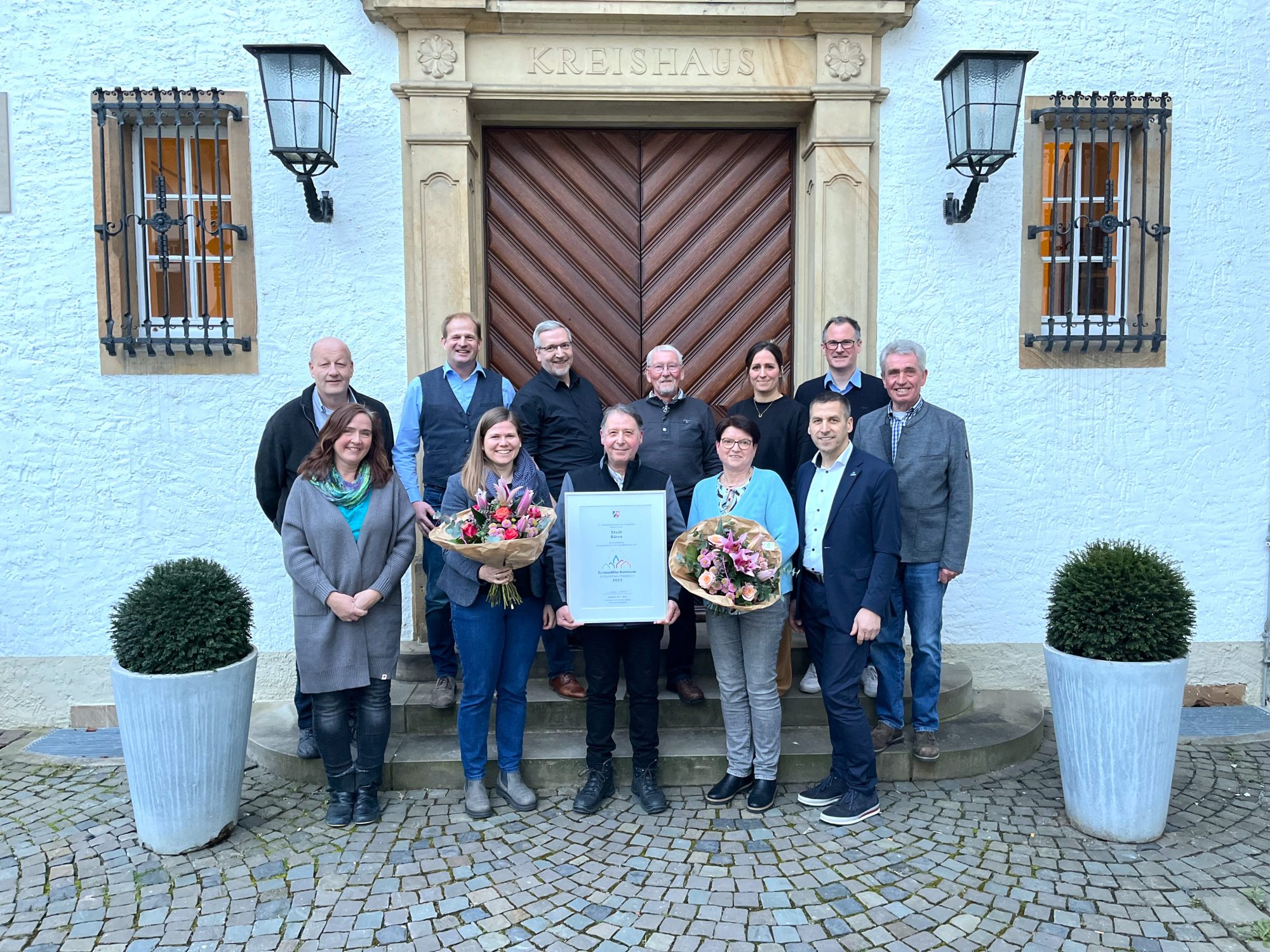 Die Vertreterinnen und Vertreter des AK Städtepartnerschaften verabschieden zusammen mit Bürgermeister Burkhard Schwuchow Gundula Stember (mit Blumen r.) als Sprecherin der Städtepartnerschaft mit Charenton und begrüßen Sabrina Nsanzabandi (mit Blumen l.) als neue Sprecherin. (Foto: Stadt Büren)