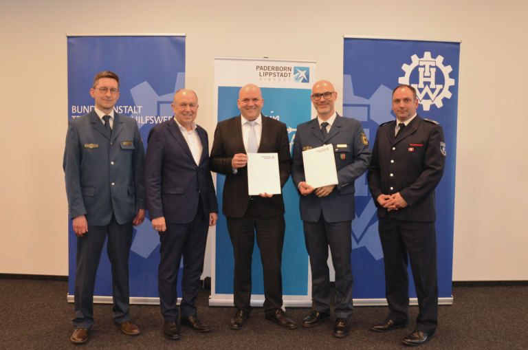 (von links) Der Regionalleiter THW Arnsberg Sascha Meyer, Landrat Christoph Rüther, Flughafenchef Roland Hüser, Landesbeauftragter NRW Herr Hafner und Flughafenfeuerwehr Chef Roland Kempkensteffen freuen sich über die landesweit erste Zusammenarbeit einer Flughafen-Feuerwehr mit dem THW. (Foto: Flughafen Paderborn / Lippstadt)