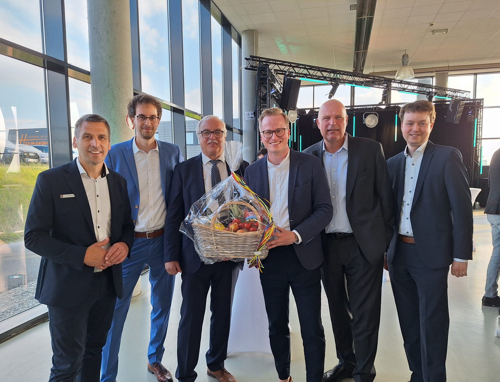Feierstunde im Quax-Hangar: Bürgermeister Burkhard Schwuchow (links) gratuliert zusammen mit Wirtschaftsförderer Michael Kubat (Mitte) dem Geschäftsführer Helmut Hirsch (3. v. l.) und dem geschäftsführenden Gesellschafter Sascha Hirsch (rechts) sowie den Gesellschaftern Andre Hirsch (2. v. l.) und Matthias Grafe (2. v. r.). (Foto: ARGUS)