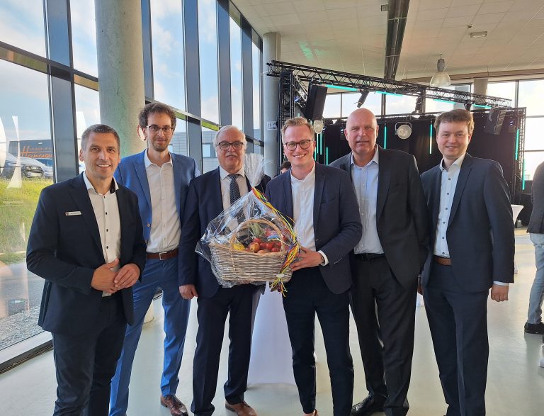 Feierstunde im Quax-Hangar: Bürgermeister Burkhard Schwuchow (links) gratuliert zusammen mit Wirtschaftsförderer Michael Kubat (Mitte) dem Geschäftsführer Helmut Hirsch (3. v. l.) und dem geschäftsführenden Gesellschafter Sascha Hirsch (rechts) sowie den Gesellschaftern Andre Hirsch (2. v. l.) und Matthias Grafe (2. v. r.). (Foto: ARGUS)