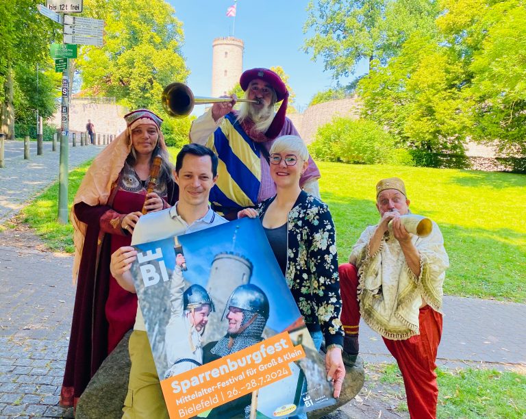 Kommet herbei zum Sparrenburgfest 2024: Jens Kramer und Katharina Schilberg von Bielefeld Marketing (vorne) laden gemeinsam mit den Akteuren von „Fogelvrei“ Elke Osterhaus, Johannes Faget und Lutz Jahr (v. l.) zum dreitägigen Burg-Spektakulum am letzten Juli-Wochenende ein. (Foto: Bielefeld Marketing GmbH)