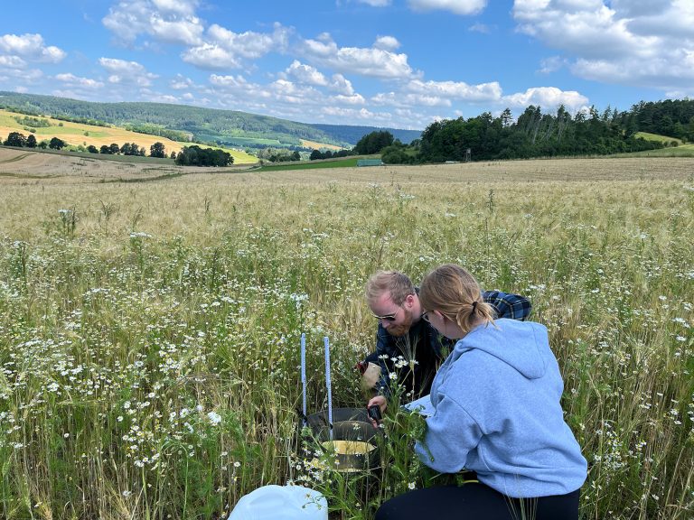 Die Studierenden Johanna Seick und Till Oberndörfer führen Versickerungsexperimente im Feld durch. (Foto: TH OWL)