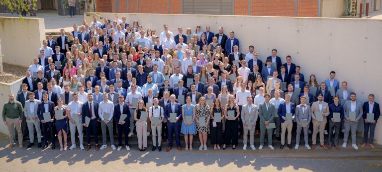 201 dual Studierende des Campus Lingen präsentieren ihre Zeugnisse vor der Halle des Campus. (Bild: Hochschule Osnabrück)