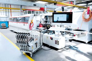 Komplexe Technologie und intuitive Bedienung: IMA Schelling hat die bewährte Kantenbearbeitungsmaschine Novimat Contour R3 mit einer neuen Steuerung ausgerüstet und hebt die automatisierte Bekantung damit auf ein neues Komfort-Level. (Foto: IMA Schelling Group)