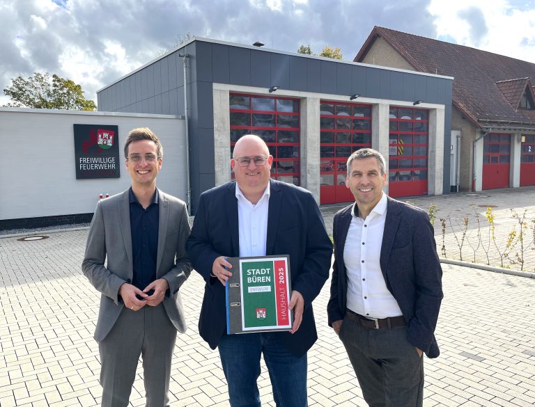 André Stadermann, Abteilungsleiter Planen/Bauen (v. l.), Kämmerer Jens Meschede und Bürgermeister Burkhard Schwuchow präsentieren den Haushaltsplanentwurf 2025 vor dem Anbau des Feuerwehrgerätehauses in Büren. (Foto: Stadt Büren)