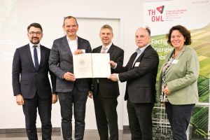 Die Urkunde nahmen Professor Dr. Jürgen Krahl, Präsident der TH OWL (2. v. l.), und Projektleiter Professor Dr. Thomas Schulte (2. v. r.) entgegen. Überreicht wurde diese von Dr. Sven Halldorn, Abteilungsleiter der Abteilung Grundsatzangelegenheiten des Bundesministeriums für Digitales und Verkehr (M.). Mit auf dem Bild die lippischen Bundestagsabgeordneten Kerstin Vieregge und Christian Sauter. (Foto: TH OWL)