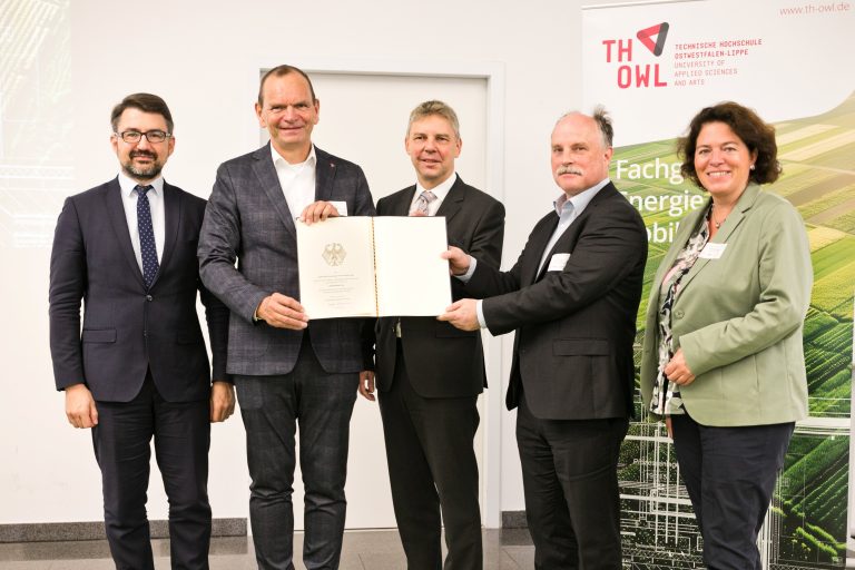 Die Urkunde nahmen Professor Dr. Jürgen Krahl, Präsident der TH OWL (2. v. l.), und Projektleiter Professor Dr. Thomas Schulte (2. v. r.) entgegen. Überreicht wurde diese von Dr. Sven Halldorn, Abteilungsleiter der Abteilung Grundsatzangelegenheiten des Bundesministeriums für Digitales und Verkehr (M.). Mit auf dem Bild die lippischen Bundestagsabgeordneten Kerstin Vieregge und Christian Sauter. (Foto: TH OWL)