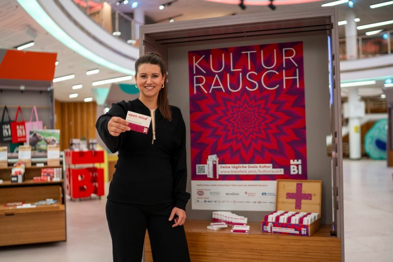 Projektleiterin Nadine Connor präsentiert die Kulturrausch-Kampagne in der neuen Tourist-Information in der Wissenswerkstadt an der Wilhelmstraße 3, wo es zu jedem Ticket eine Packung mit „open mind“-Pastillen für kulturelle Nebenwirkungen gibt. (Foto: Bielefeld Marketing | Adrian Stein)