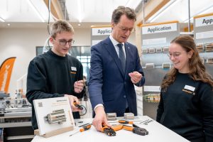 Bei seinem Weidmüller-Besuch verdrahtete Ministerpräsident Hendrik Wüst selbst mit der innovativen SNAP IN-Anschlusstechnologie – unter der Anleitung von Florian Sundermann, Auszubildender zum Mechatroniker, und Clara Lorenz, Dualstudentin Digital Engineering und Auszubildende zur Mechatronikerin. (Foto: Weidmüller Interface GmbH & Co. KG)