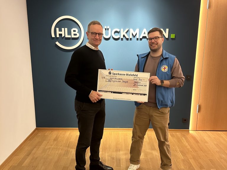 Über eine Spende des Bielefelder Unternehmens HLB Stückmann in Höhe von 800 Euro freut sich der Leiter der Bahnhofsmission Bielefeld, Martin Zawieracz (r.), mit Dietmar Engel. (Foto: Denise Fischer / HLB Stückmann)