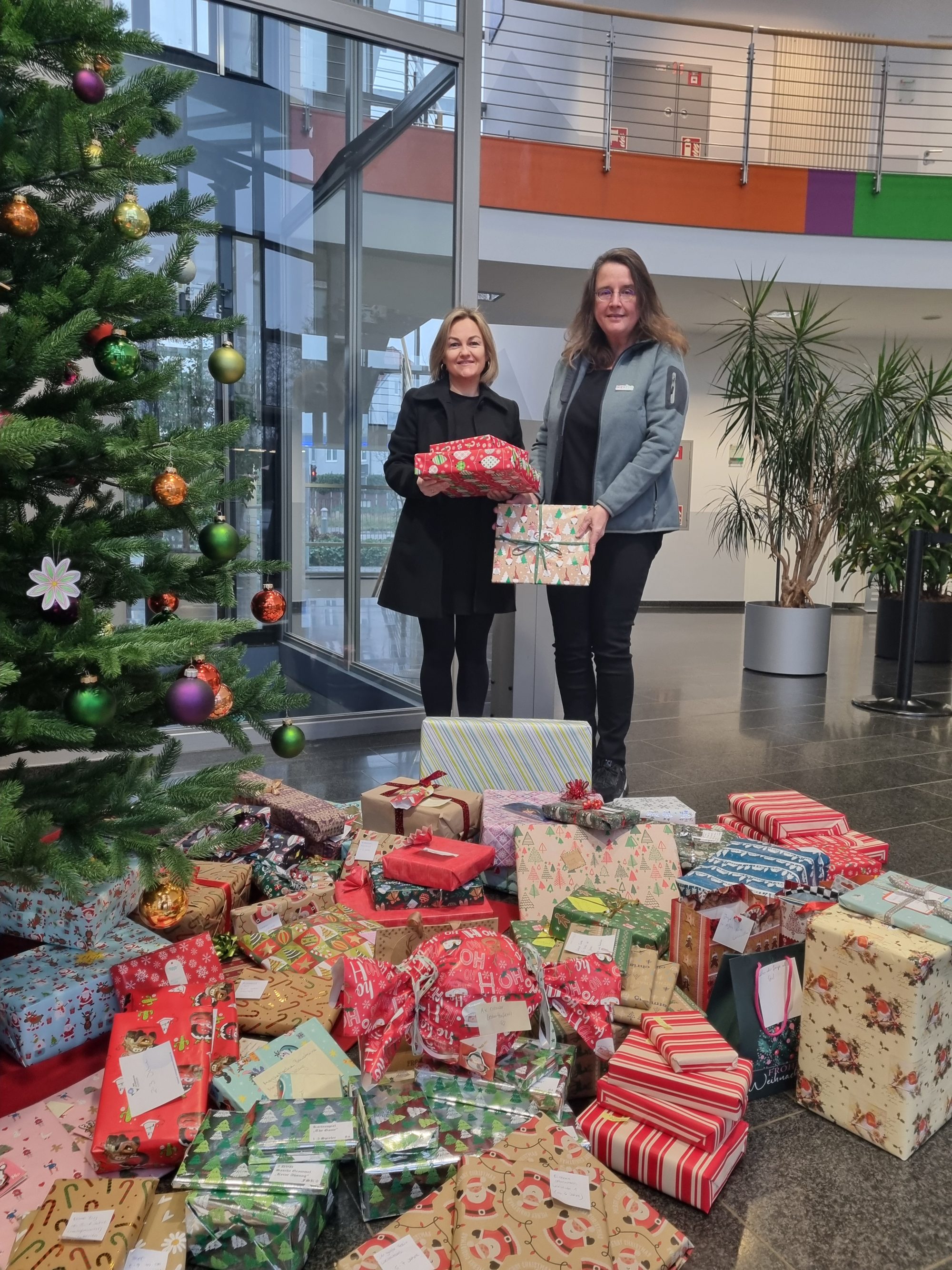 Über die vielen Geschenke für die Kinder vom Westfälischen Kinderdorf Lipperland freuen sich Heike Sommerkamp (Leiterin Öffentlichkeitsarbeit Westfälisches Kinderdorf Lipperland) und Josephin Ulrich (Pressesprecherin BKK GILDEMEISTER SEIDENSTICKER). (Foto: BKK)