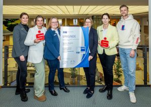 Freuen sich über die Auszeichnung (v.l.) Theresa Dreier, Personalentwicklung der Sparkasse Osnabrück, Lisa Hövelmeyer, Julia Theiling (beide Ausbildung), Juliane Hünefeld-Linkermann, IHK-Geschäftsbereichsleiterin, Jasmin Michel, Personalleiterin und Henrik Schober, IHK-Projektkoordinator Ausbildungsbotschafter. (Foto IHK/Holger Bulk)