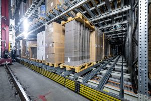 Ein Satellitenlager® von Westfalia Technologies – hier das Verpackungslager der Züger Frischkäse AG – lagert hochkompakt und materialschonend. Dank der mehrfachen Schienenauflage in den Lagerkanälen halten Paletten länger. Das verhindert Störungen und Ausfallzeiten. (Foto: Westfalia Technologies GmbH & Co. KG / Marcello Engi)