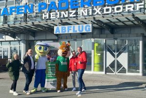 Partner beim Paderborner Osterlauf 2025 (von links): Luisa Peitz (Marketing, Flughafen Paderborn/Lippstadt), Roland Hüser (Geschäftsführer, Flughafen Paderborn/Lippstadt) und Maskottchen Homie freuen sich gemeinsam mit Osterlauf-Maskottchen Paola sowie Mareen Walbaum (Sportmanagerin, SC Grün-Weiß Paderborn) und Christian Stork (Organisationsleiter, Osterlauf) auf den 6. Paderborn/Lippstadt Airport 5 km Fit and Fun Lauf. (Foto: Flughafen Paderborn/Lippstadt)