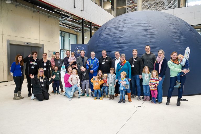 Vorfreude auf die erste Planetariums-Vorführung: Kitakinder, Eltern und Mitarbeitende des MINTmachCLUB.Lippe mit Landrat Dr. Axel Lehmann (6. v.r.) und Astrophysiker Tilo Hohenschläger (8. v.l.) vor dem mobilen Planetarium. Mit dabei: Marc Thiel (Geschäftsführung Lippe Bildung eG, 7. v.l.), Caroline Adolph (4. v.l.), Thomas Mahlmann (7. v.r.), Nadine Siekmeier (3. v.l.) Nadine Tober (2. v.l.), Oliver Hülsmann (4. v.r.), alle Lippe Bildung eG. (Foto: Lippe Bildung eG)