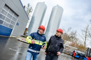 Frank Wehrmann (links), Geschäftsführer von Wehrmann Transport, und Gebäudemanager Matthias Gering inspizieren die beiden Pufferspeicher, die mit elf Metern Höhe jeweils ein Volumen von 45.000 Litern fassen. (Foto: Simone Reukauf)