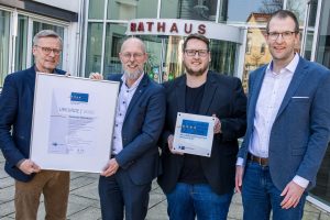 Freuen sich über die Ehrung der Gemeinde Wallenhorst als "Ausgezeichneter Wohnort für Fachkräfte" (von links nach rechts): Otto Steinkamp, Bürgermeister der Gemeinde Wallenhorst, IHK-Geschäftsbereichsleiter Frank Hesse, Nils Tiedemann (Gemeinde Wallenhorst) und Christian Weßling, IHK-Projektleiter Wirtschaftspolitik. (Bildquelle: Gemeinde Wallenhorst/André Thöle)