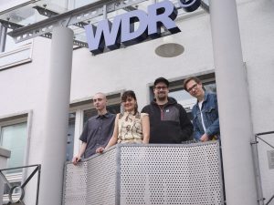 Ausstellung KI und Fotografie bei den „Nachtansichten“ im Bielefelder WDR-Studio: (v.l.) Die ausstellenden Studierenden und Absolvent:innen Emil Dietrich, Vanessa Fengler und Jon Grote mit Ausstellungskurator Prof. Adrian Sauer (Foto: HSBI)