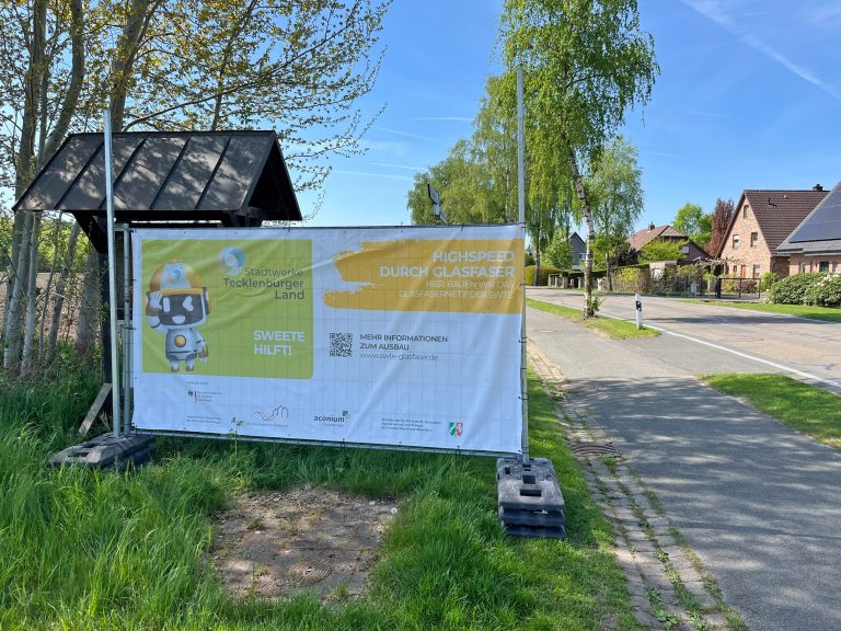 Die ersten Baustellen-Banner zum geförderten Glasfaserausbau sind inzwischen aufgestellt worden. Nach Vorgaben der Fördermittelgeber sind die Banner notwendig, um alle Bürgerinnen und Bürger, die Anspruch auf einen geförderten Hausanschluss haben, zu informieren. Foto: Stadtwerke Teck-lenburger Land (Foto: SWTE)