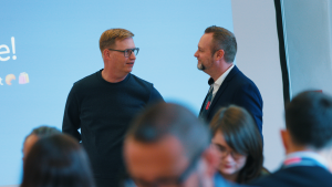 quadt-CEO Oliver Schroer beim E-Commerce-Breakfast in Bielefeld mit Teilnehmenden im Hintergrund