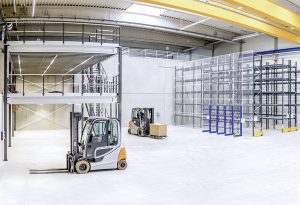 Lagerhalle mit Regalanlagen, Bühne und Gabelstaplern