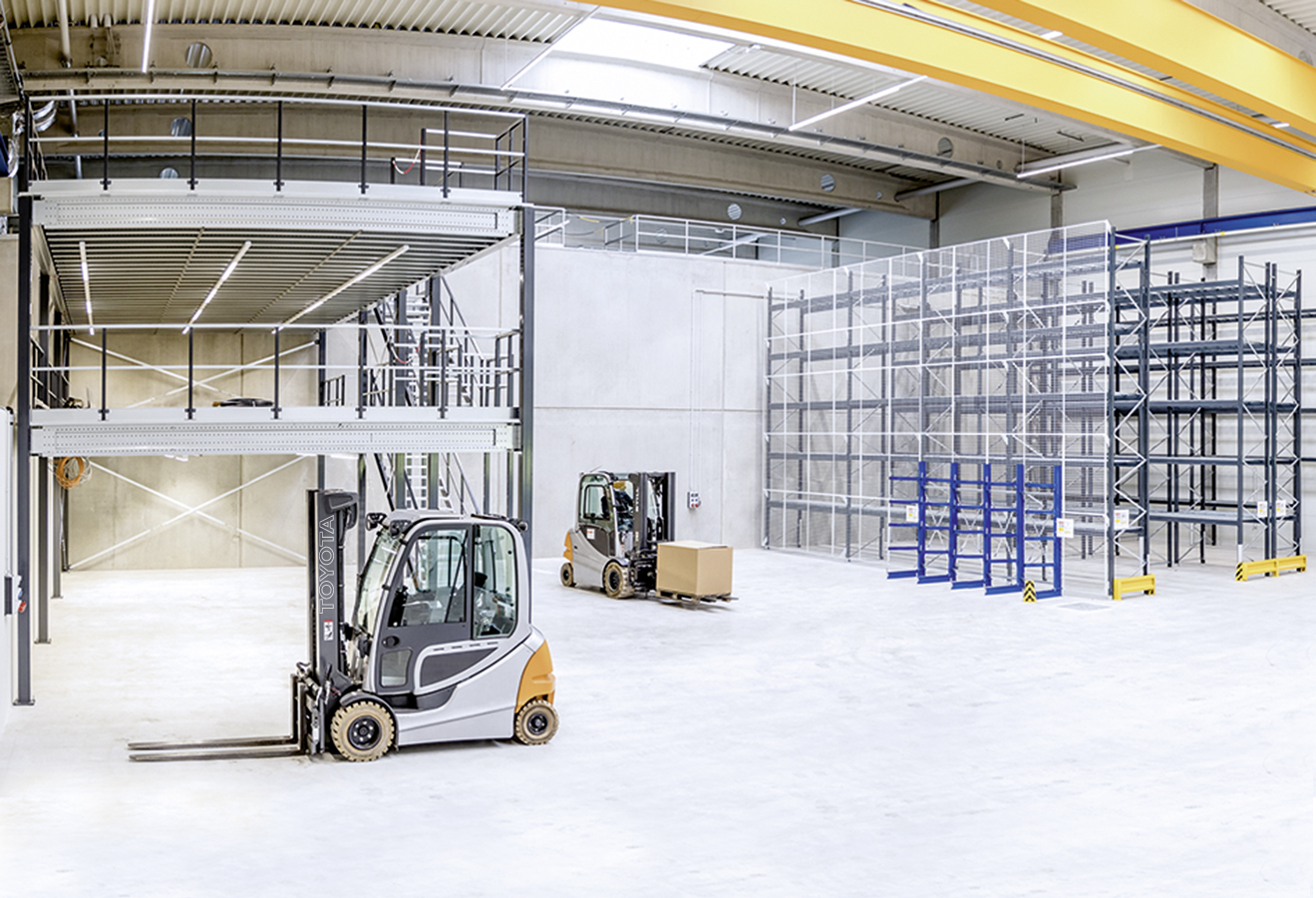 Lagerhalle mit Regalanlagen, Bühne und Gabelstaplern
