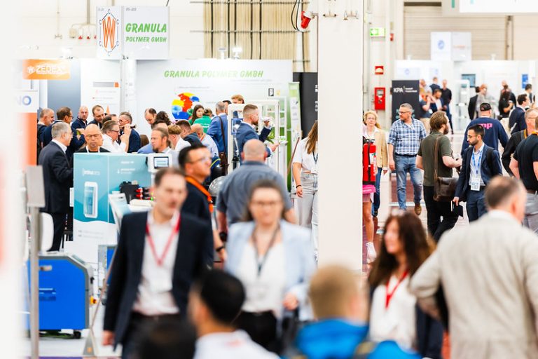 Besucherinnen und Besucher bewegen sich durch die Messehallen von KUTENO und KPA in Bad Salzuflen zwischen Ausstellerständen der Kunststoffbranche.