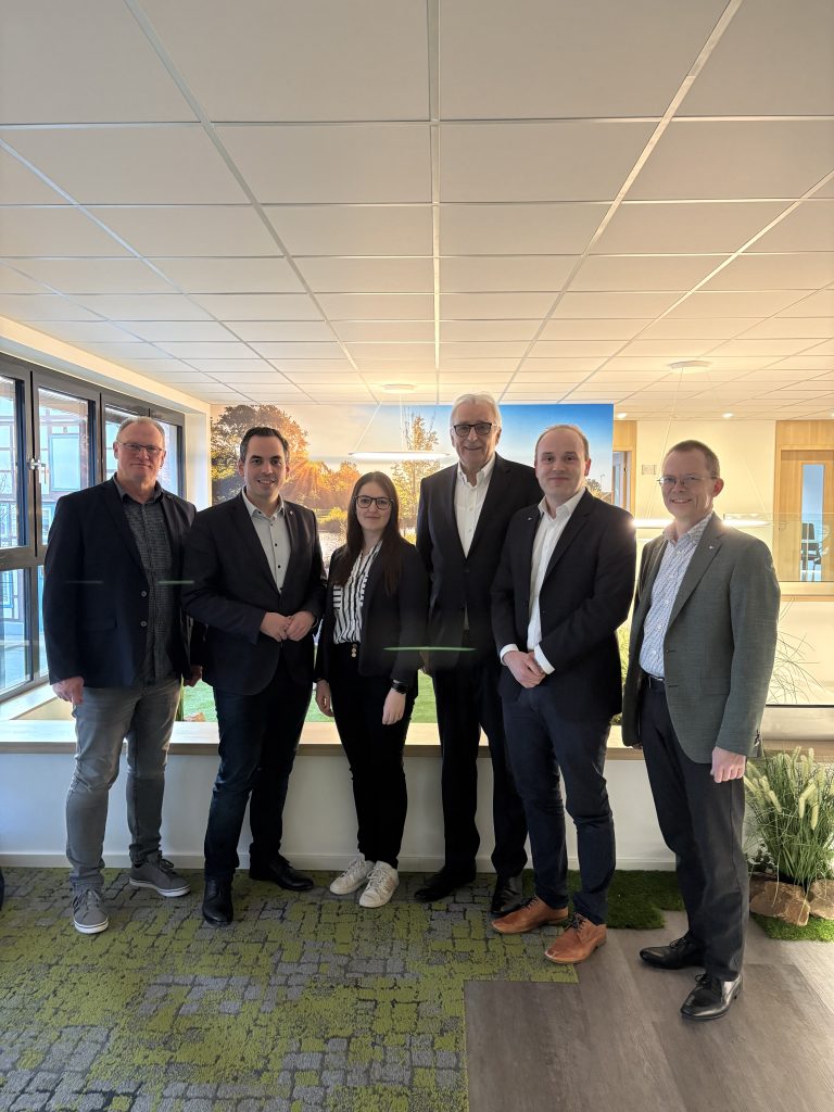 Sechs Personen aus Wirtschaft, Stadtverwaltung und IHK stehen beim Kommunalen Wirtschaftsgespräch im Co-Working-Space Emmerhub in Lügde zusammen.