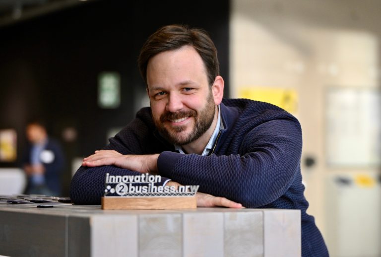 Dr. Florian Hengsbach mit einem 3D-gedruckten Logo aus Stahl des Hochschulverbunds innovation2business.nrw