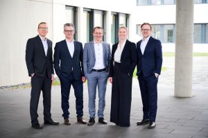 Geschäftsleitung von exxis vor einem modernen Unternehmensgebäude
