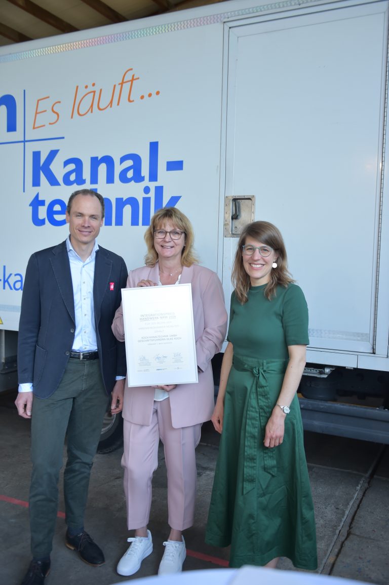 Verena Schäffer, Silke Koch und Josef Trendelkamp bei der Übergabe des Integrationspreises Handwerk NRW vor einem Fahrzeug von Koch Kanaltechnik