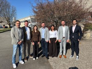 Sieben Personen von DK Kunststoff-Service und RadiciGroup stehen im Freien vor einem Unternehmensgebäude.