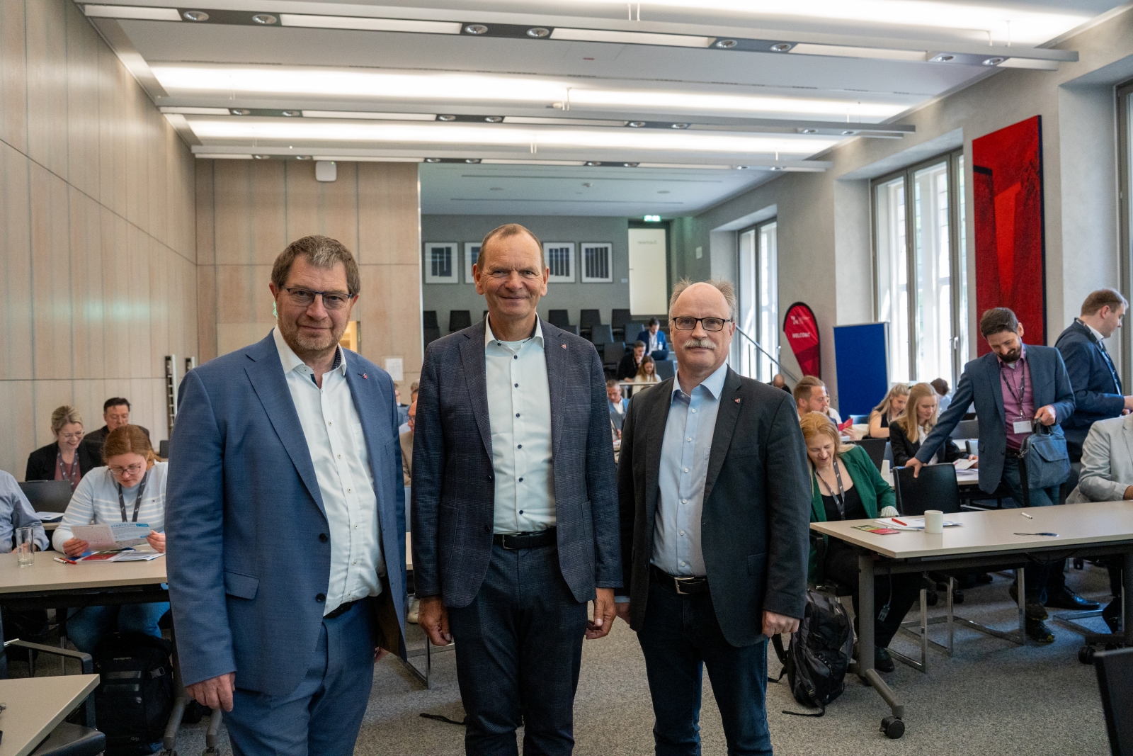 Professor Stefan Witte, TH-OWL-Präsident Jürgen Krahl und Institutsleiter Thomas Schulte stehen bei der FJRG-Fachtagung im historischen Rathaus Lemgo vor den Teilnehmenden.