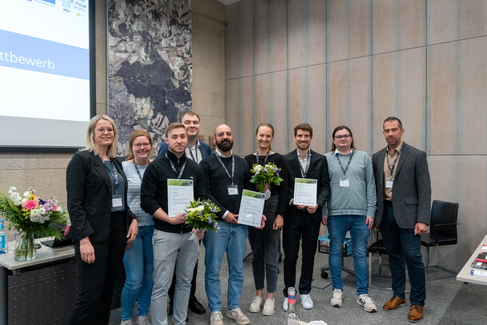 Gruppenfoto der Ausgezeichneten und Organisierenden des FJRG-Nachwuchsförderpreises mit Urkunden und Blumensträußen im historischen Rathaus Lemgo.