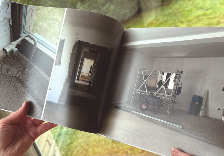 Aufgeschlagenes Hausbuch mit Fotos einer Umbauphase und Baustellensituation