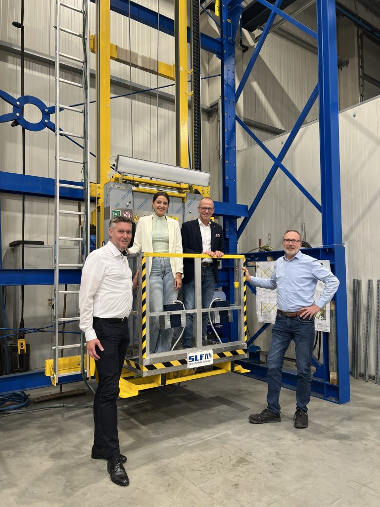 Christian Gaidies, Stefanie Westers, Bürgermeister Oliver Kellner und Michael Bahlinghorst in der Produktionshalle von SLF Oberflächentechnik in Emsdetten