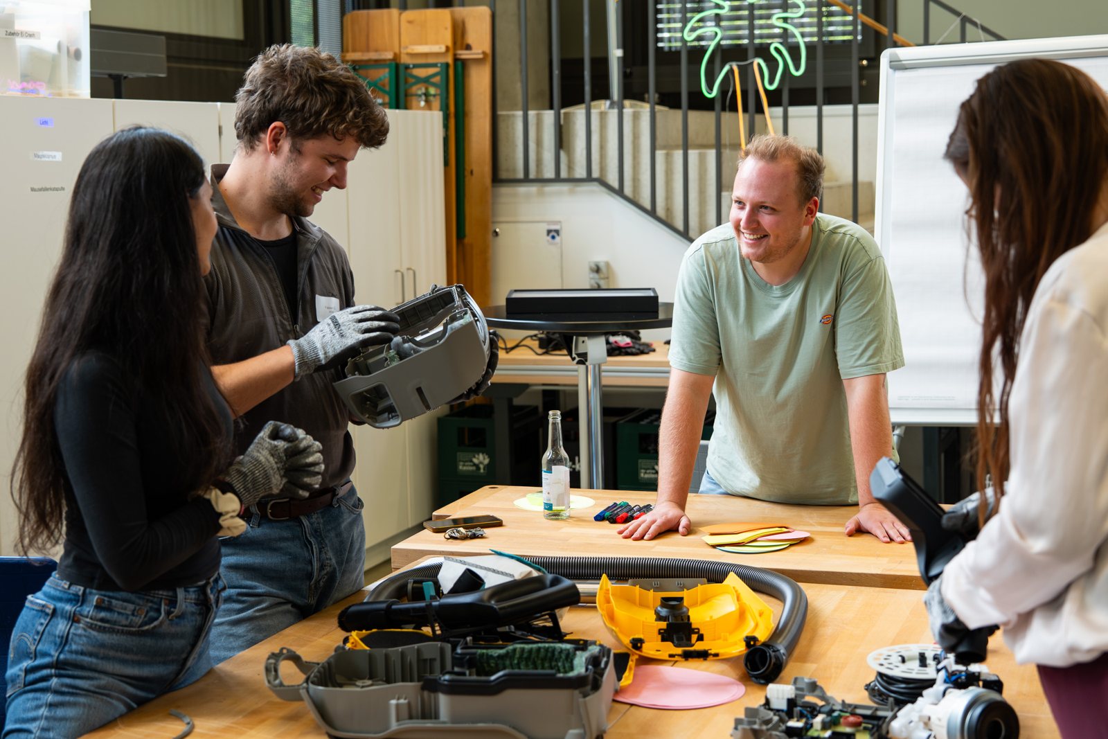 Studierende untersuchen einen zerlegten Staubsauger beim Workshop an der HSBI