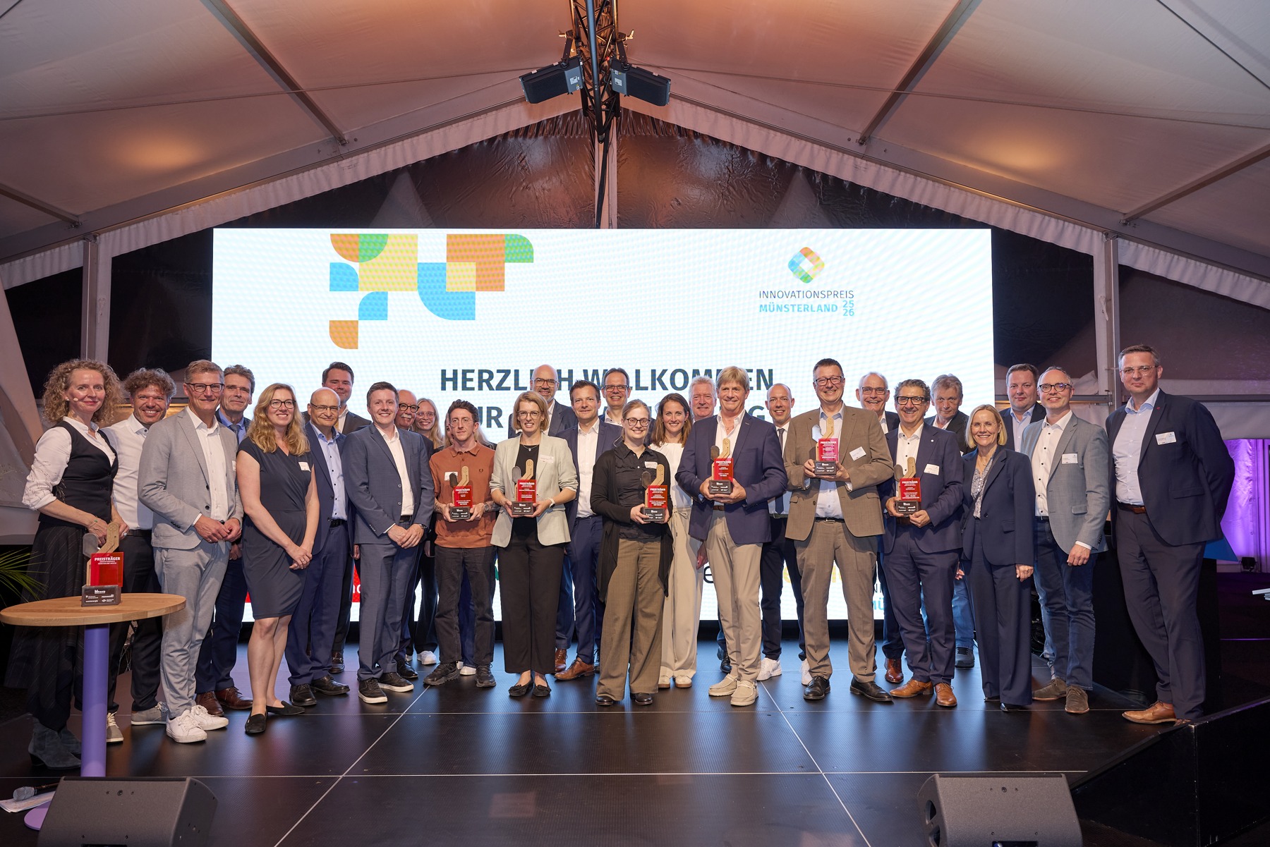 Preisträgerinnen und Preisträger des Innovationspreises Münsterland mit Gästen auf der Bühne
