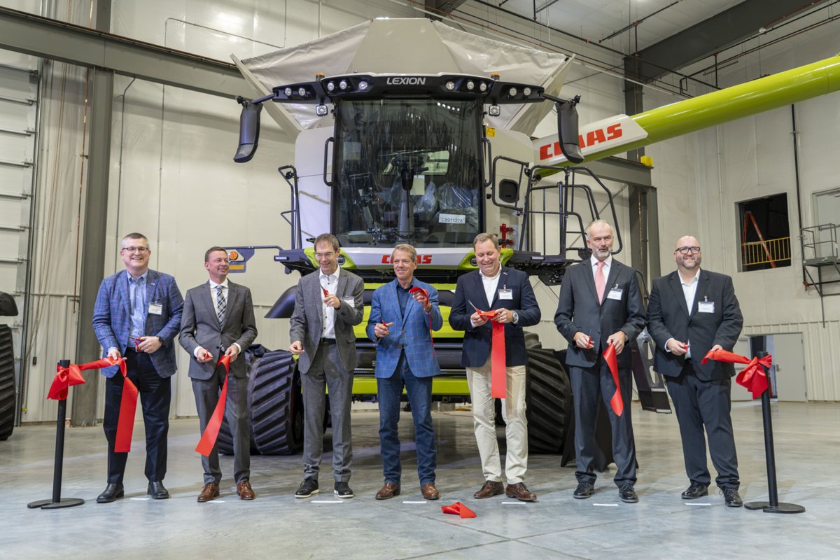 Vertreter von CLAAS und Gäste durchschneiden bei der Eröffnung in Omaha ein rotes Band vor einem LEXION-Mähdrescher.