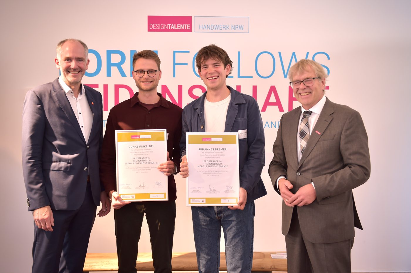 Vier Männer bei der Preisverleihung von DesignTalente Handwerk NRW; zwei halten ihre Urkunden.